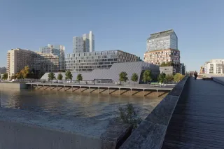 A bridge spanning a river with buildings in the background, creating a picturesque scene of urban architecture and natural beauty.