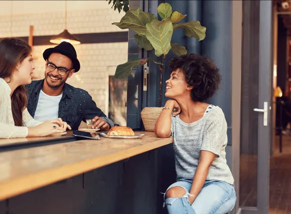 Three friends enjoying a meal together at a cozy restaurant.