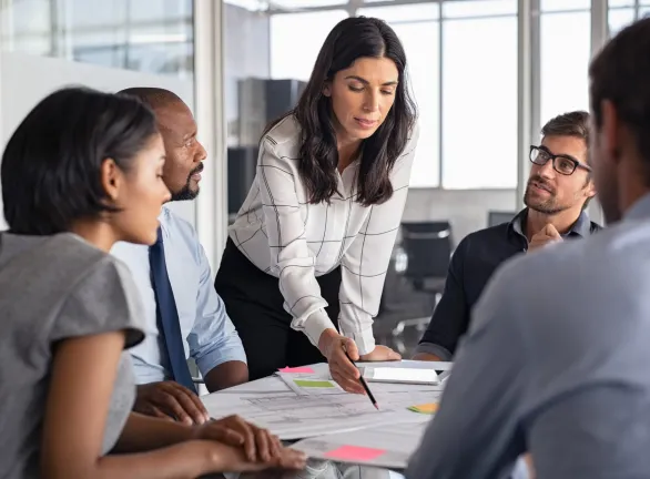 A businesswoman makes a presentation to her colleagues at a meeting.